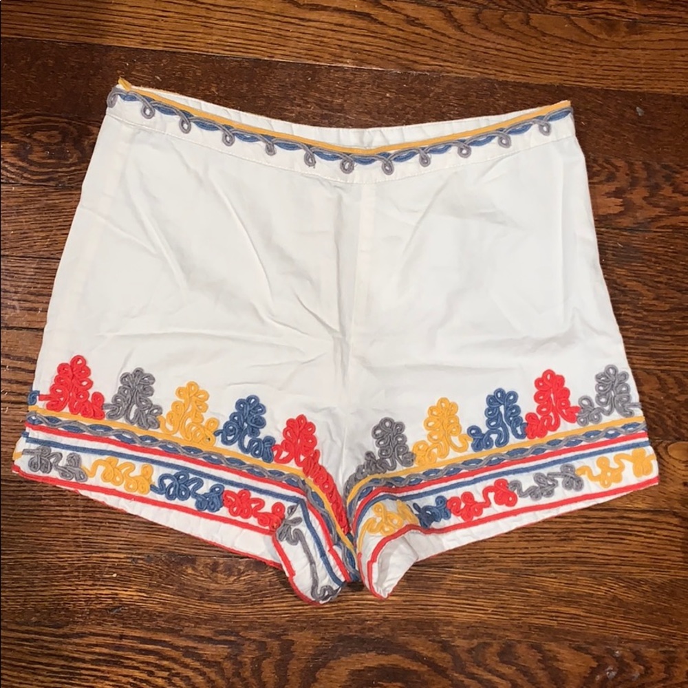 White canvas shorts with subtle colorful accents.